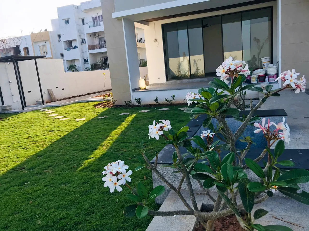 Win Landscape residential villa garden with fresh lawn and flowering plants in Chennai